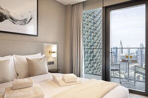 A hotel room with a large bed, a nightstand, a wall-mounted lamp, and a balcony with a city view. - NEW | 3BR Burj Fountain NYE View | Address (Dubai)