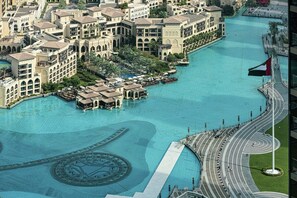 A large hotel complex with multiple buildings, a central water feature, and a flag. - NEW | 3BR Burj Fountain NYE View | Address (Dubai)