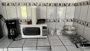 A kitchen with a microwave, coffee maker, and dish rack.
