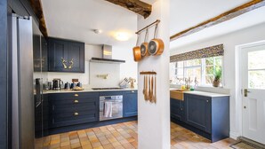 Una cucina moderna con mobili scuri, pavimento piastrellato e una finestra vista verde.