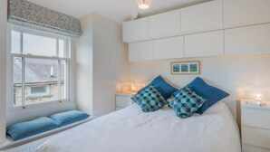 A bedroom with a large bed, two bedside tables, a window with a view, and a ceiling light fixture. - Sedbergh Penthouse - KingBed - Tv - Wifi (Sedbergh)