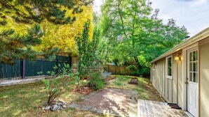 A backyard with a wooden deck, a small garden area, and a shed. - Delightful Urban Retreat (Seattle)