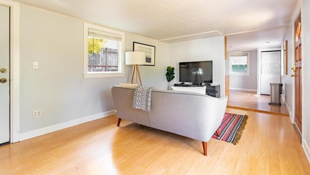 A modern living room with a grey sofa, a flat-screen TV, and a lamp. - Delightful Urban Retreat (Seattle)