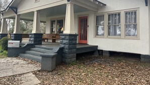 Una casa con porche, puerta roja y buzón.