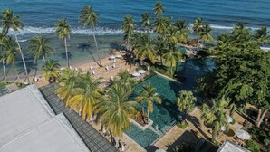 A resort with a pool, beach, and ocean view.