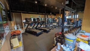 Una palestra con tapis roulant, macchinari per pesi e pesi liberi.