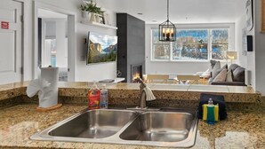 Een moderne keuken met een granieten aanrecht, een roestvrijstalen spoelbak en een open haard.