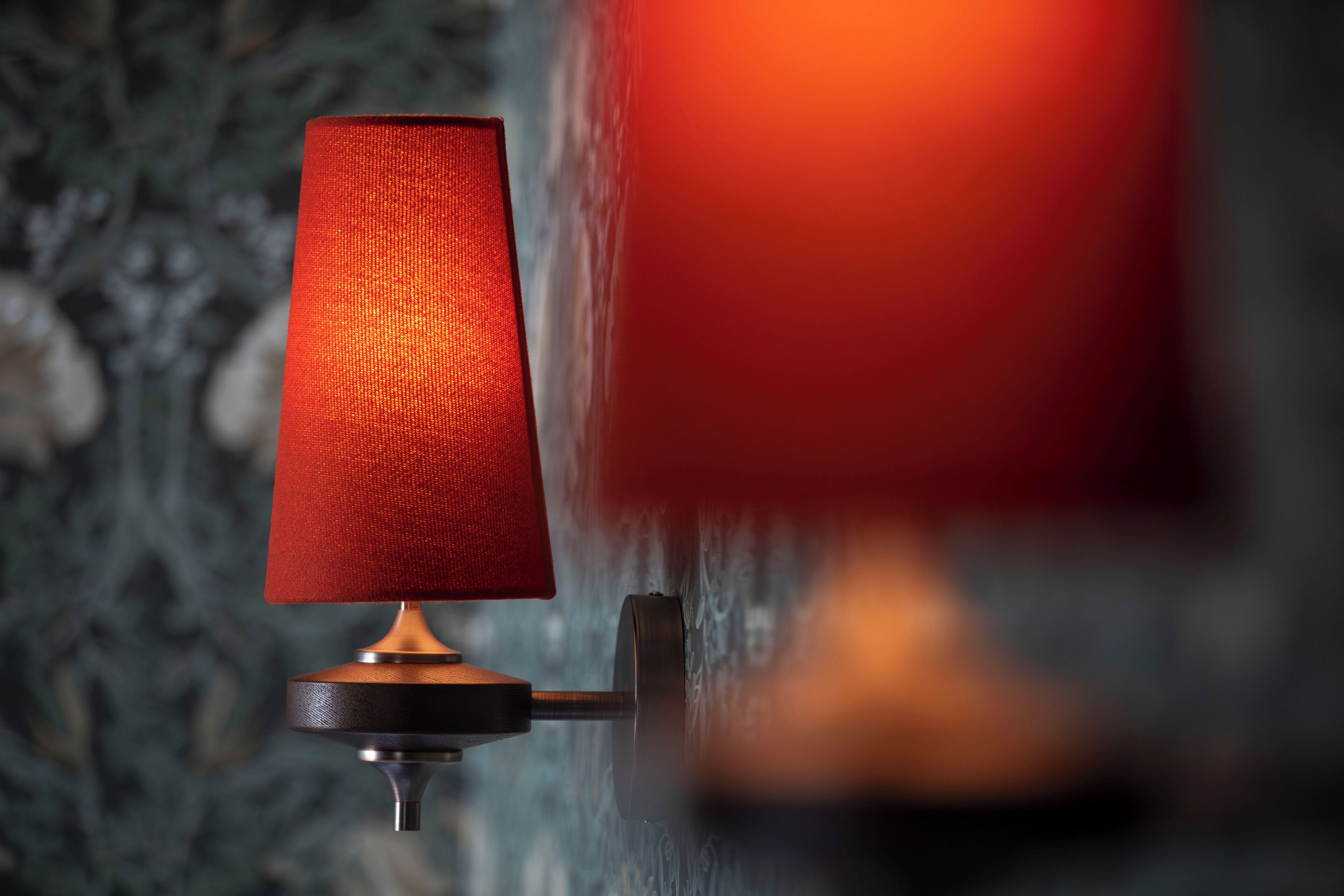 A wall-mounted lamp with a red shade.