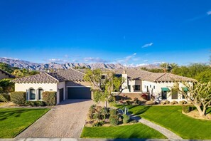 A two-story house with a tiled roof, a garage, and a well-maintained lawn. - INDIO Madison Estates Desert Retreat near PGA  West and Coachella - 4600 SQFT (Indio)