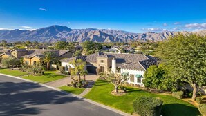 A residential area with houses, a clear sky, and mountains in the background.