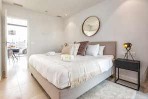 A bedroom with a bed, bedside table, lamp, and a mirror on the wall. - Carma | pool- sea view - terrace (Fuengirola)