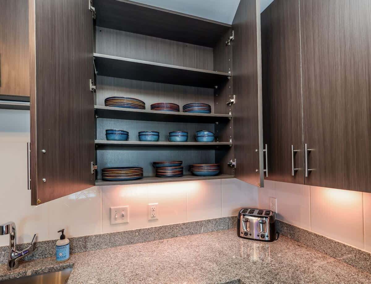 Eine Küche mit dunklen Holzschränken, einer Granit Arbeitsplatte und einem Toaster.