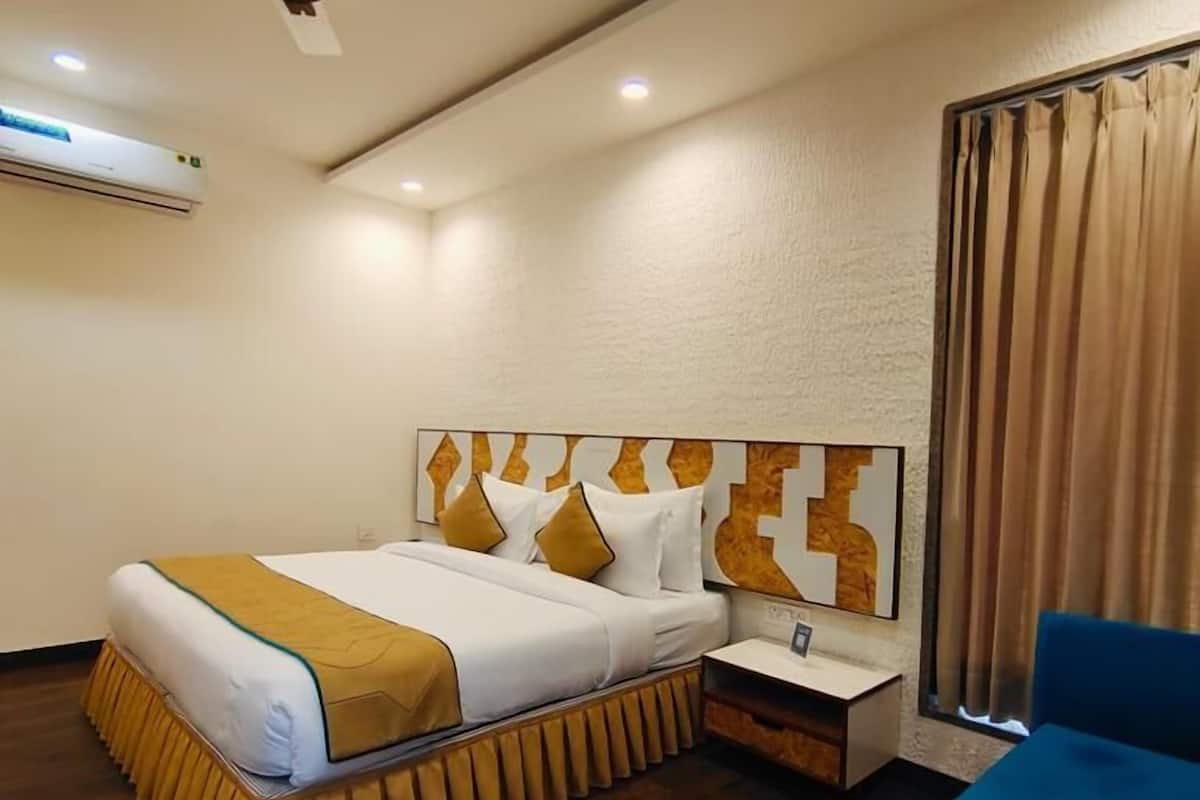 Een hotelkamer met een bed, nachtkastje en plafondventilator.