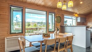 A wooden interior with a dining table, chairs, and a kitchen area. -  located in the heart of Oneroa, landscaped garden and 5 minute's walk to beach (Waiheke Island)