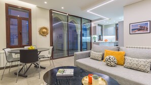 A modern living room with a sofa, a dining table, and a coffee table. - Bubble Beach 2-BR in Souk Batroun with Parking
 (Batroun)