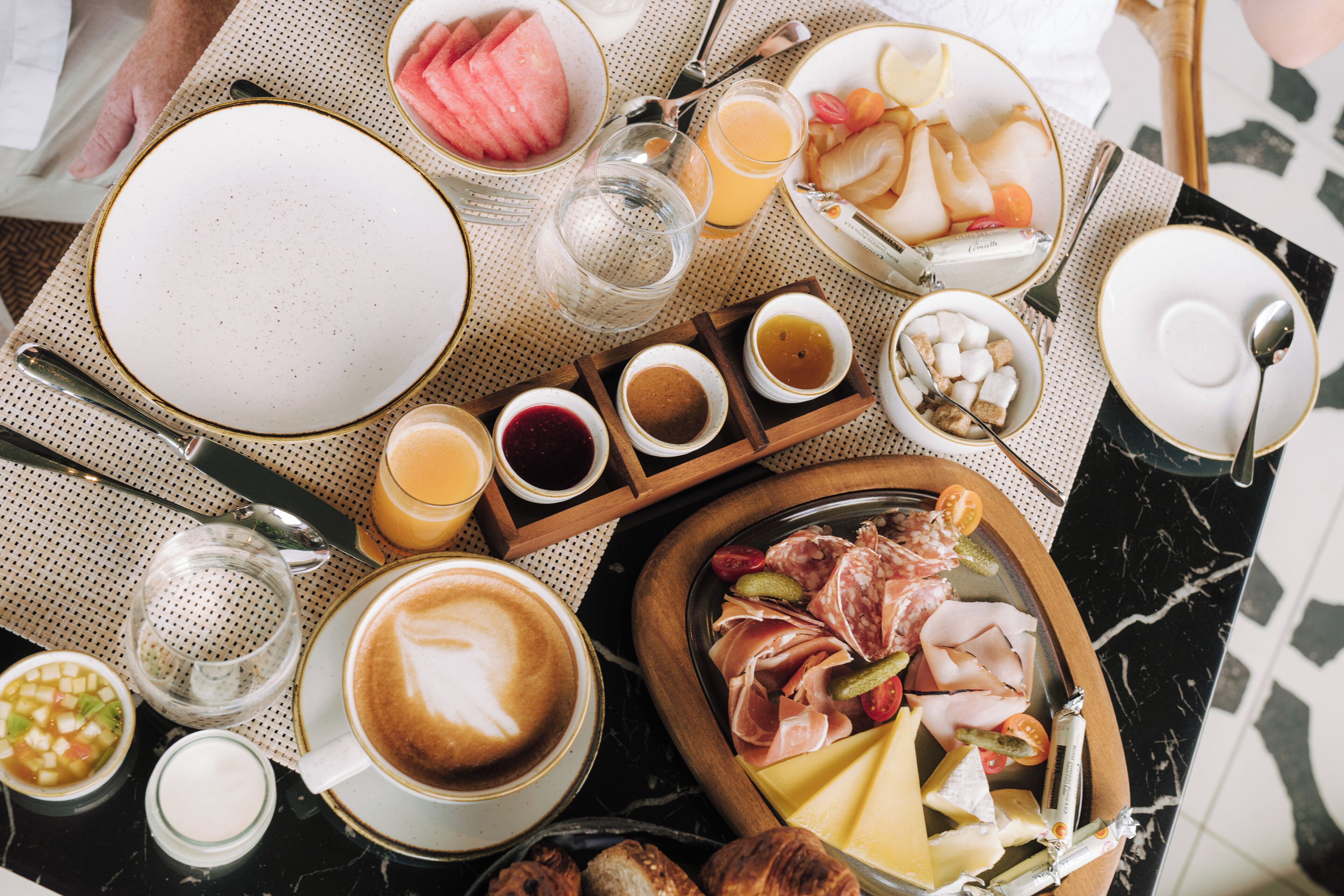 Un bufé de desayuno con diversos alimentos, bebidas y una taza de café.