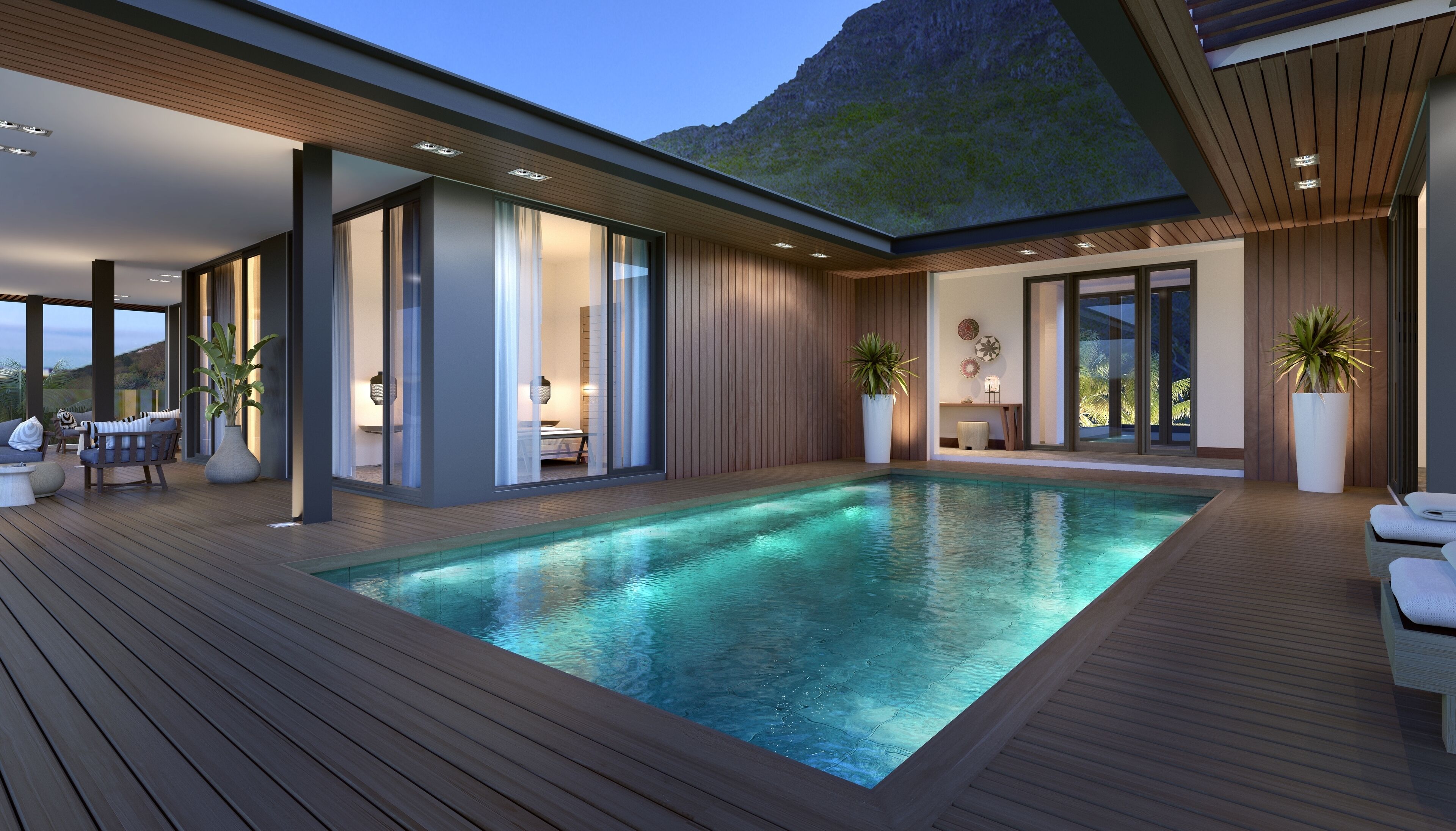 Un área de piscina moderna al aire libre con cubierta de madera, una silla de descanso y un espacio de estar con una mesa y sillas.