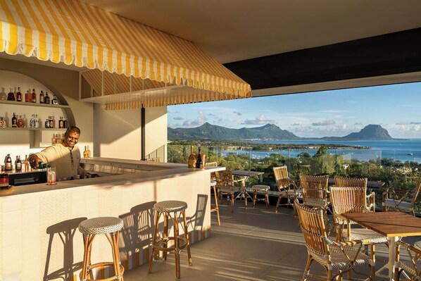 A bar area with a view of the sea and mountains. - Legend Hill Residences & Spa (Black River)