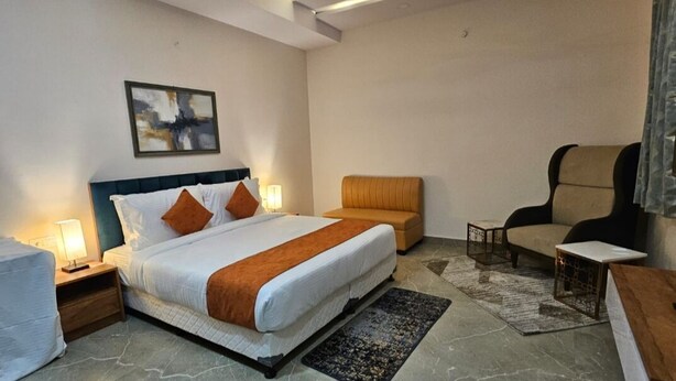 Ein Hotelzimmer mit einem großen Bett, einer Couch, einem Sessel und einem kleinen Tisch.