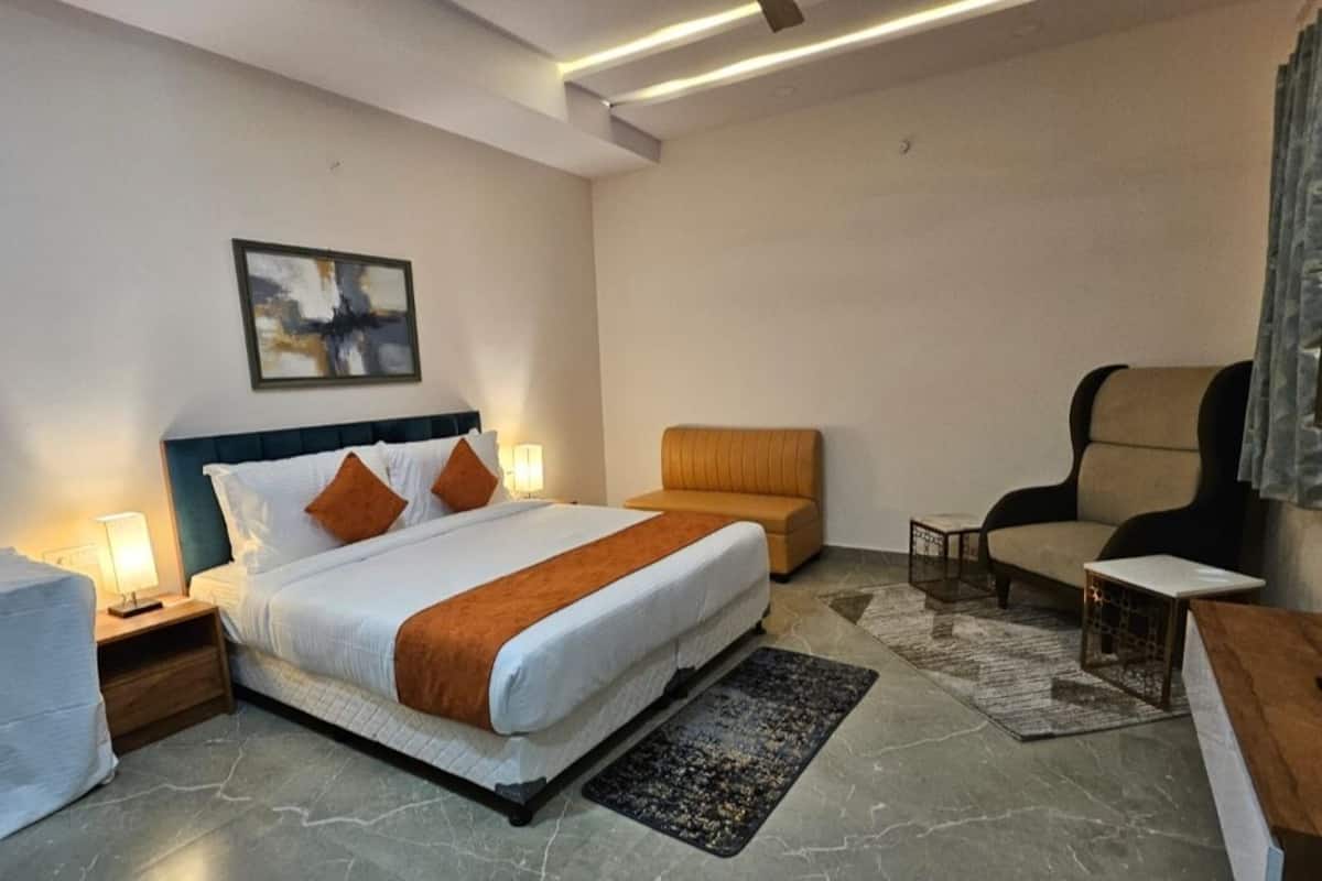 Ein Hotelzimmer mit einem großen Bett, einer Couch, einem Sessel und einem kleinen Tisch.