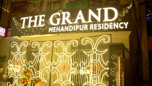 Grand Mehandipur Residency mit beleuchteter Beschilderung und dekorativen Blumenarrangements.