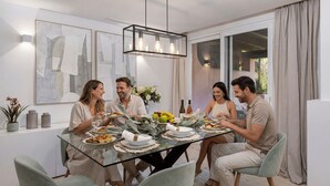 A dining area with a glass table, chairs, and a modern chandelier. - Villa Federer: Best holiday rental in Marbella Old town (Marbella)