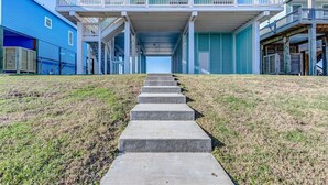 A building with a covered walkway leading to a balcony. - Laguna Cove Cabin, Canal Front (Bolivar)