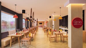 Ein modernes Restaurant mit Holztischen und -stühlen, einer Bar in der Mitte und Pendelleuchten.