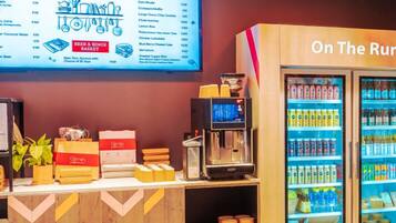 Un restaurante con un cartel de menú, una máquina de café y un refrigerador para bebidas.