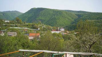 A rural landscape with houses, a checkered awning, and a green metal structure.