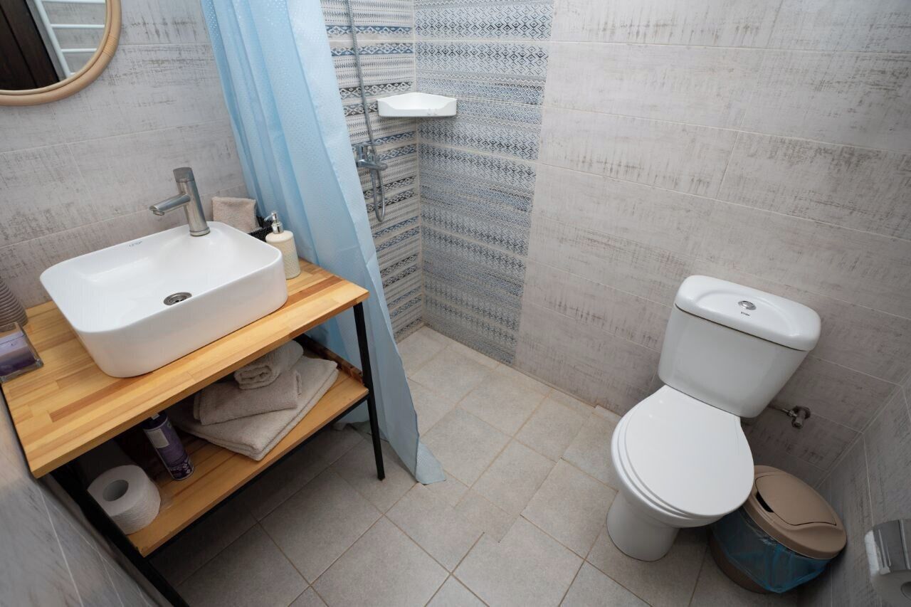 A bathroom with a white sink, toilet, and shower.