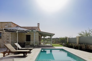 A poolside area with lounge chairs and a covered patio.