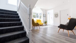 Een modern interieur met een trap, een receptiebalie en een deur.