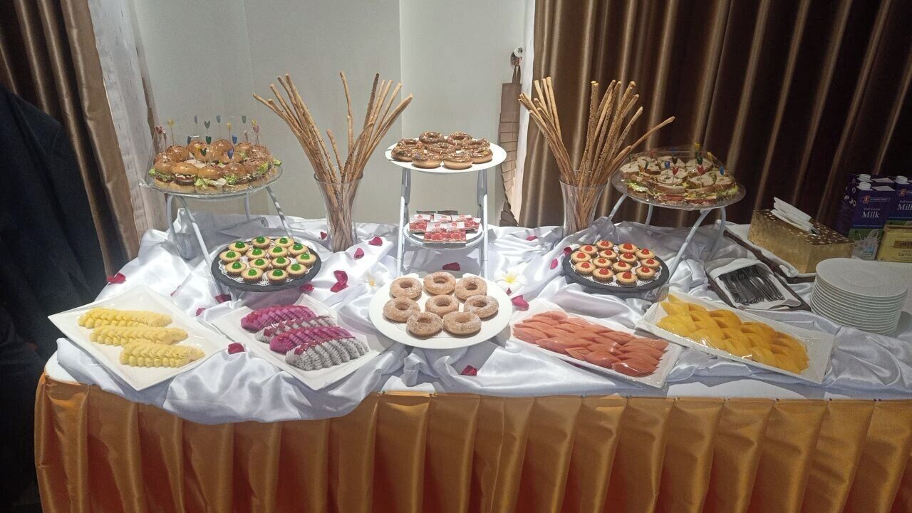 A buffet table with various food items and utensils.