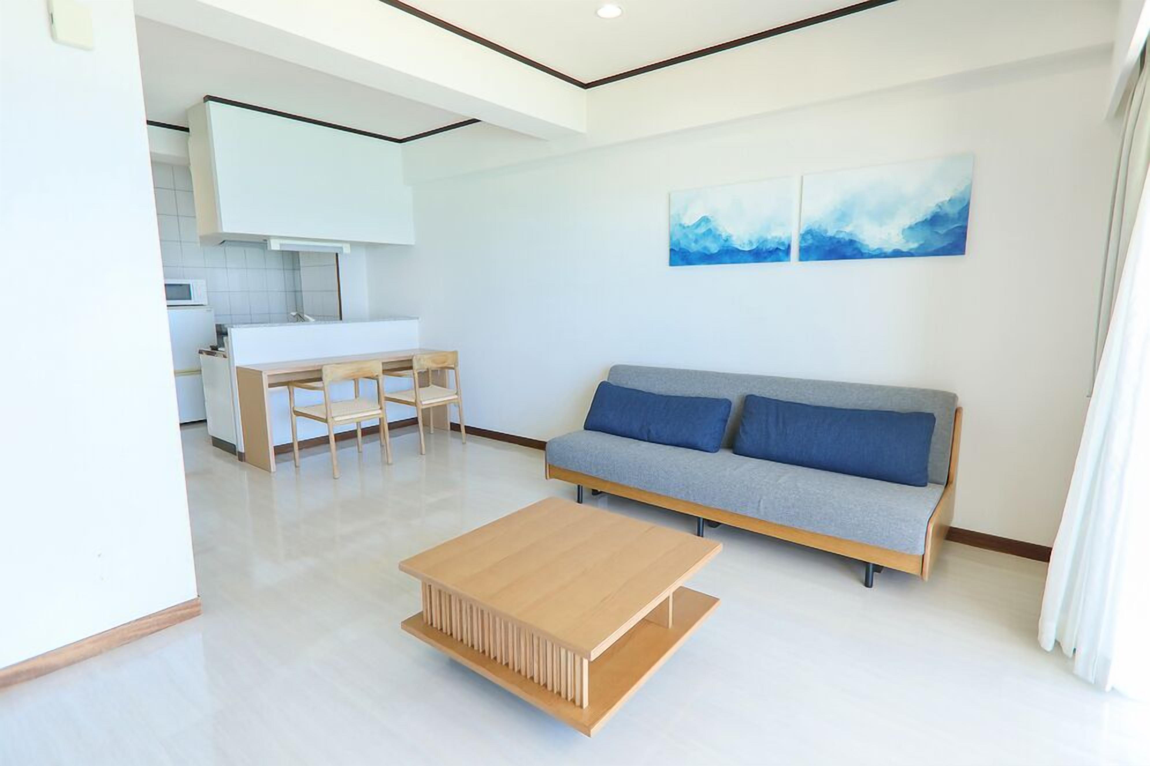 Una sala de estar moderna con un sofá, una mesa de centro y un comedor con sillas y una mesa.