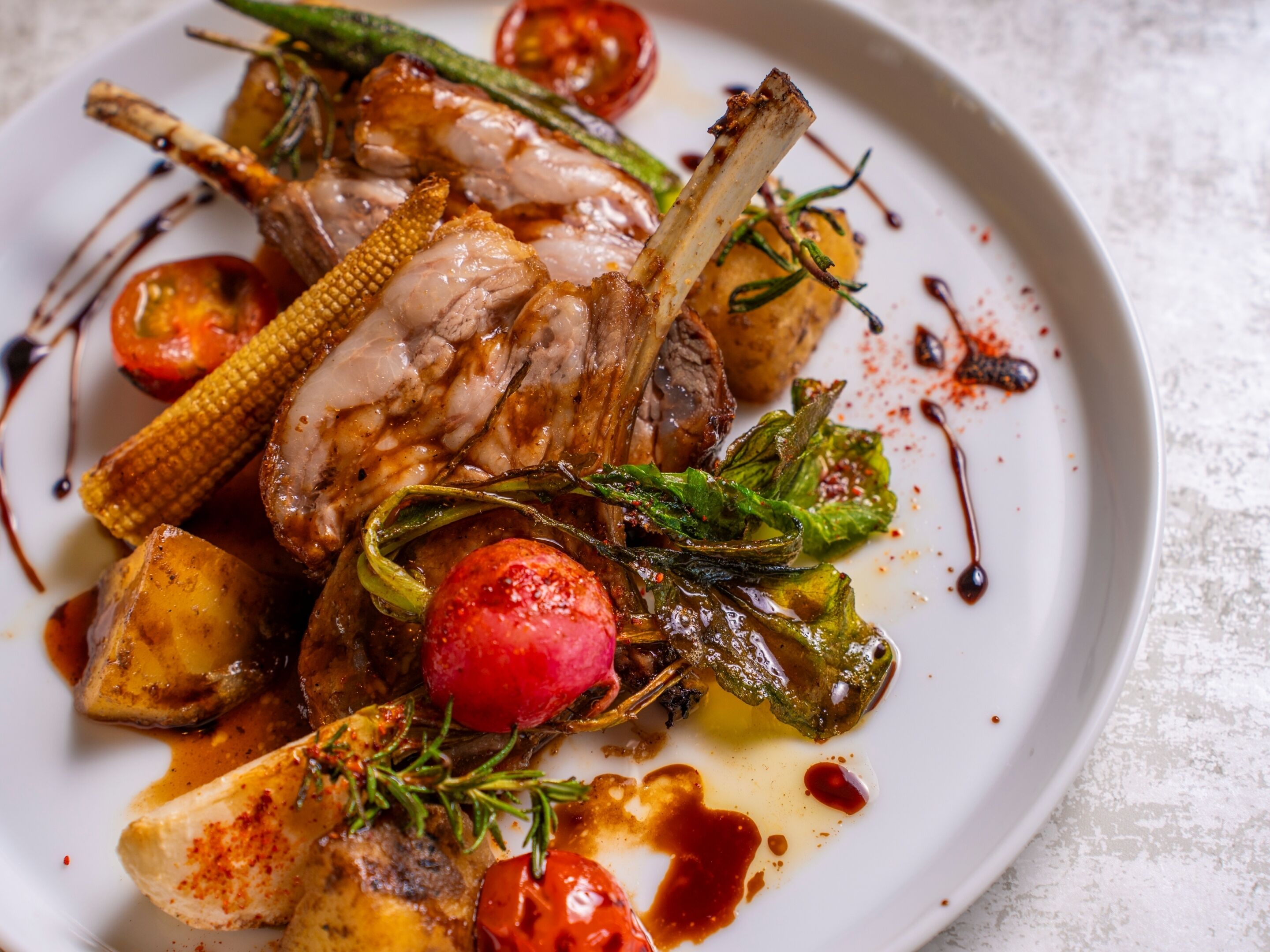 Un plato de cordero asado con verduras.