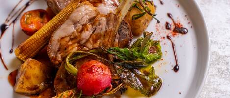 Un plato de cordero asado con verduras.