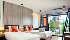 Una habitación de hotel con dos camas, un ventanal grande y un equipo de aire acondicionado.