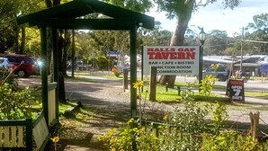 A sign for Halls Gap Tavern advertising a bar, cafe, bistro, and accommodation.