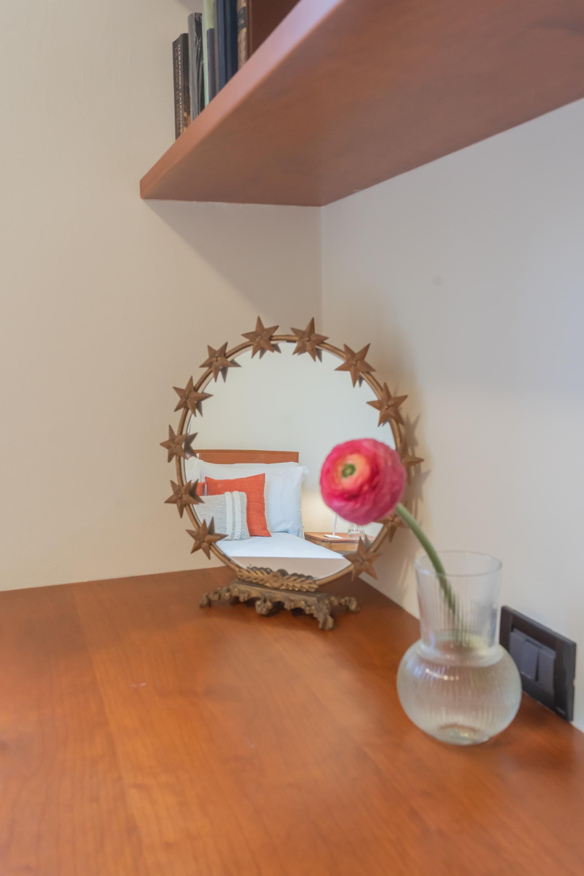 A wooden table with a glass vase containing a single flower.