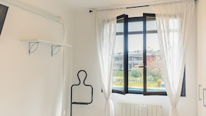 A room with a large window, white curtains, a radiator, and a black towel rack. - Fior di Loto - Italian Homing (Desenzano del Garda)