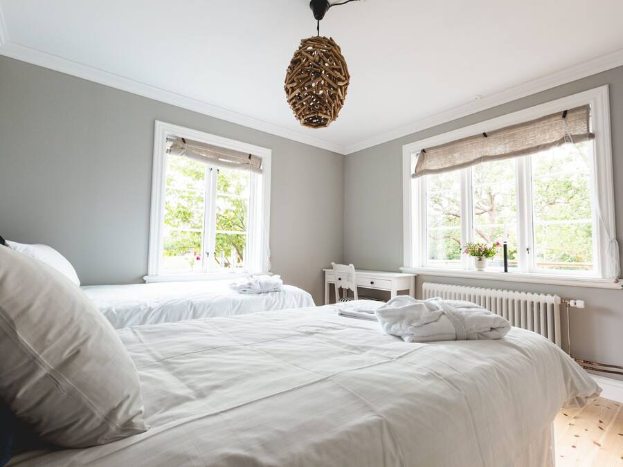 Una habitación de hotel con dos camas, un escritorio y un radiador.