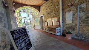 Un edificio rústico de piedra con techo de madera y un letrero que muestra el menú.