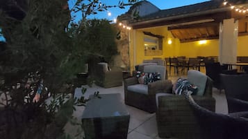 An outdoor patio area with seating arrangements and string lights.