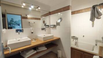 Une salle de bain moderne avec deux lavabos, un grand miroir et un espace douche.