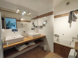 Un baño moderno con dos lavamanos, un espejo grande y una zona de ducha.