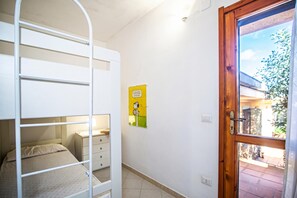 A bunk bed with a small desk, a wooden door, and a window with a view of the outside. - 3 Le Perle Di Stintino (Stintino)