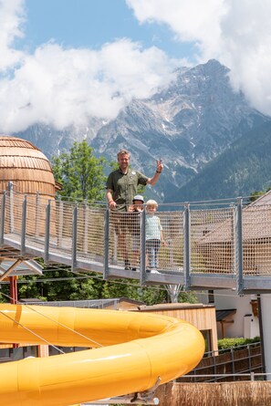 A man and a child on a rope bridge with a mountain backdrop. - EdeR FriDa – Family Hotel – Tuttiii KomPletti ALL InKlusiv (Maria Alm am Steinernen Meer)