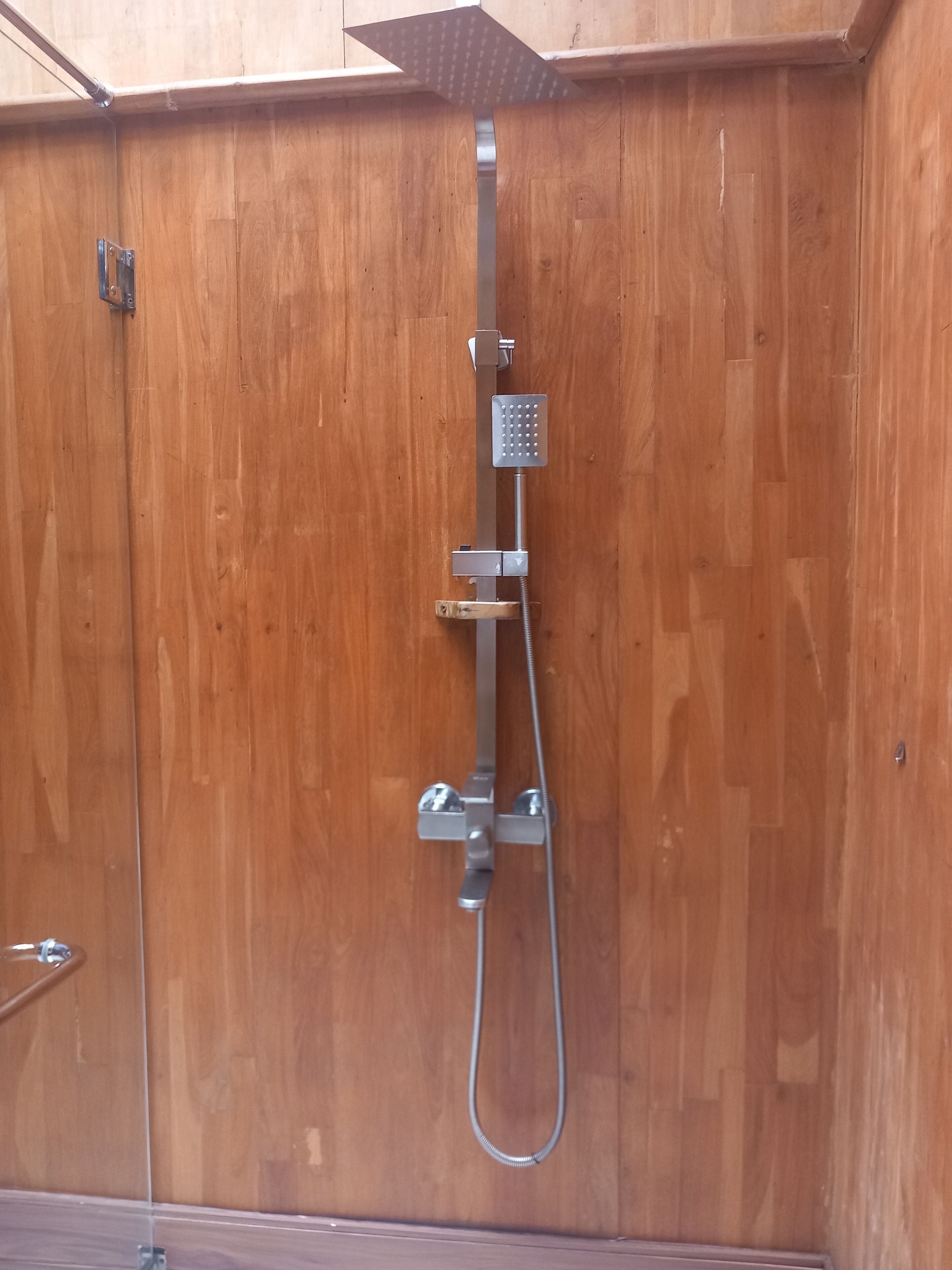 A wooden door with a built-in shower system.