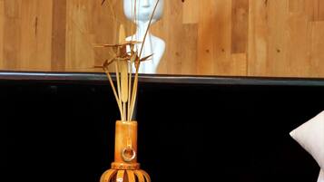 A wooden wall, a white bust sculpture, and a vase with flowers.